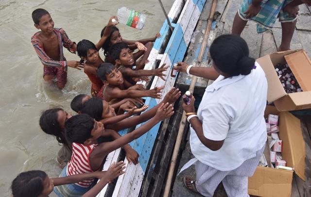 A medical official distributes medicine to children in the flood-affected Sagolikota area of Morigaon district in India's northeastern Assam state on August 18, 2017. (AFP) A medical official distributes medicine to children in the flood-affected Sagolikota area of Morigaon district in India's northeastern Assam state on August 18, 2017. (AFP)