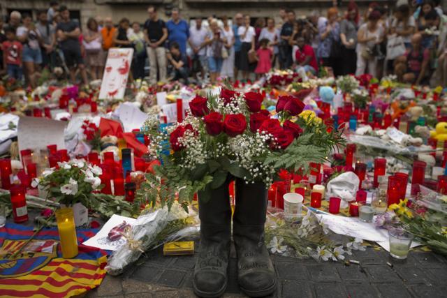 Two boots with flowers left by firefighters from Barcelona are seen next to flags, messages and candles to the victims on Barcelona's historic Las Ramblas promenade on the Joan Miro mosaic. (AP Photo) Two boots with flowers left by firefighters from Barcelona are seen next to flags, messages and candles to the victims on Barcelona's historic Las Ramblas promenade on the Joan Miro mosaic. (AP Photo)