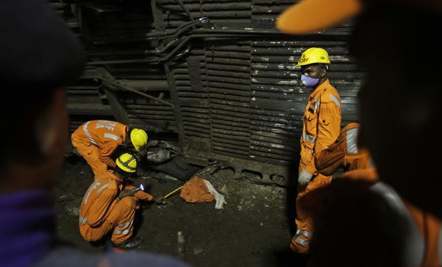 Rescuers try to retrieve the body of a victim from upturned coaches of the Kalinga-Utkal Express after an accident near Khatauli, in Uttar Pradesh. (AP Photo)