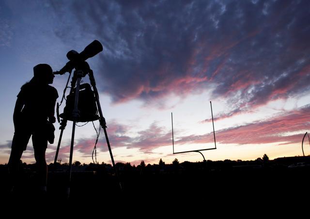 A woman looks through a telescope on the football field at Madras High School the evening before a solar eclipse in Madras, Oregon. (Reuters) A woman looks through a telescope on the football field at Madras High School the evening before a solar eclipse in Madras, Oregon. (Reuters)