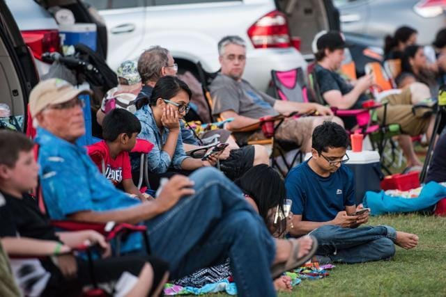People wait for the start of a drive-in movie at the Historic Columbia Speedway August 20, 2017 in Columbia, South Carolina. Columbia is one of the prime destinations for viewing Monday's solar eclipse, and NASA expects clear weather to bring over a million visitors to the state. (AFP)