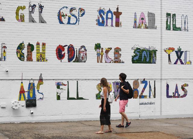 Pedestrians walk past a hand painted ad for Delta Airlines on a building wall in New York. (AFP) Pedestrians walk past a hand painted ad for Delta Airlines on a building wall in New York. (AFP)