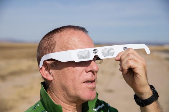 Martin Ferreira, a total eclipse enthusiast, tries out protective eye wear while waiting out standstill traffic on the side of a rural farm road near Madras, Oregon. (AFP Photo) Martin Ferreira, a total eclipse enthusiast, tries out protective eye wear while waiting out standstill traffic on the side of a rural farm road near Madras, Oregon. (AFP Photo)