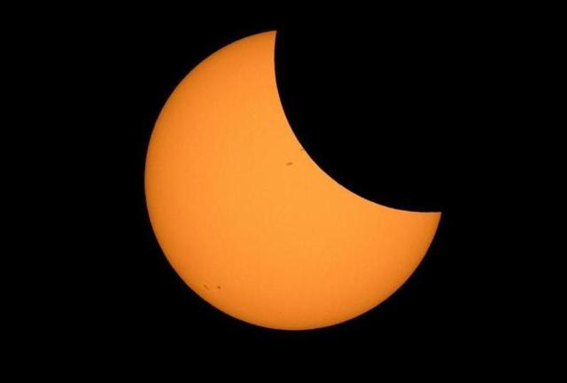 The moon starts passing in front of the sun during a solar eclipse seen from Ross Lake, Northern Cascades National Park, Washington. (AFP)