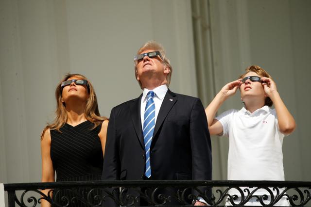 US President Donald Trump watches the solar eclipse with first Lady Melania Trump and son Barron from the Truman Balcony at the White House in Washington. (REUTERS)