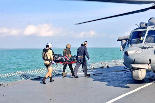Royal Malaysian Navy personnel carry a body onto a US Navy helicopter from USS America during a search and rescue operation for survivors of the USS John S. McCain ship collision in Malaysian waters on August 23, 2017. (Reuters) Royal Malaysian Navy personnel carry a body onto a US Navy helicopter from USS America during a search and rescue operation for survivors of the USS John S. McCain ship collision in Malaysian waters on August 23, 2017. (Reuters)