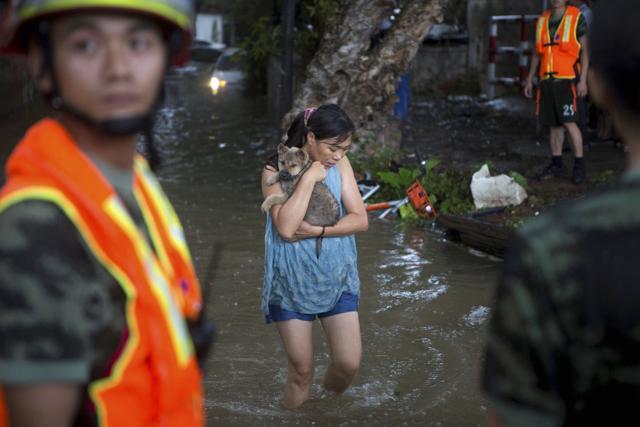 A woman holds on to her pet as they evacuate from flood waters caused by Typhoon Hato and the tide in Guangzhou in southern China's Guangdong province Wednesday Aug 23, 2017. (AP) A woman holds on to her pet as they evacuate from flood waters caused by Typhoon Hato and the tide in Guangzhou in southern China's Guangdong province Wednesday Aug 23, 2017. (AP)