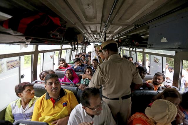 Police officers question passengers as they check for supporters of the Dera Sacha Sauda sect near Panchkula on Thursday. (AP)
