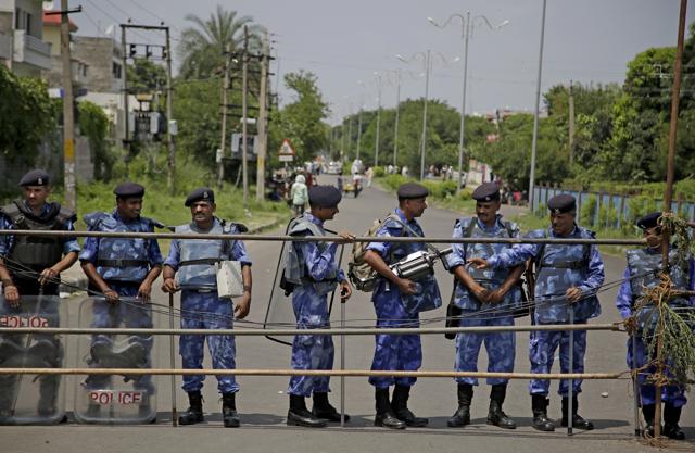 Anti-riot policemen stand guard on a barricaded road leading to a court in Panchkula on Thursday. (AP)