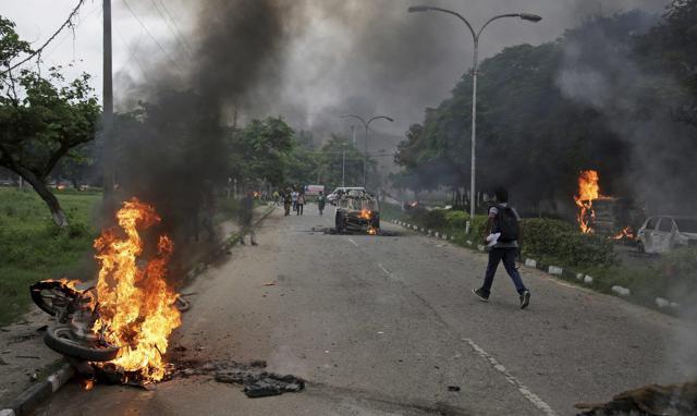 Vehicles set alight by Dera Sacha Sauda sect members in Panchkula on Friday. (AP) Vehicles set alight by Dera Sacha Sauda sect members in Panchkula on Friday. (AP)