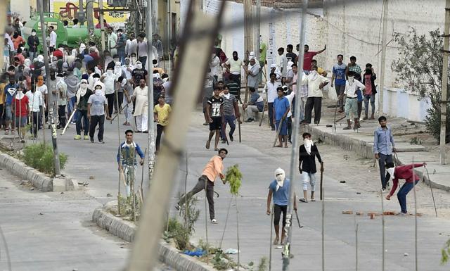 Alleged followers of Ram Rahim pelt stones at security personnel in in Sirsa. (PTI) Alleged followers of Ram Rahim pelt stones at security personnel in in Sirsa. (PTI)