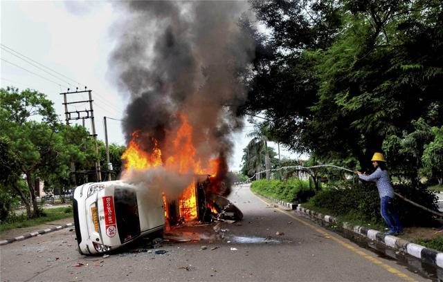 A firefighter tries to douse a blaze after a vehicle belonging to a television channel was burnt in Panchkula on Friday. (PTI)