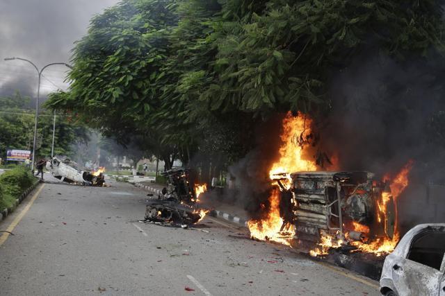 Vehicles set alight by Dera Sacha Sauda sect members burn in the streets of Panchkula on Friday (AP) Vehicles set alight by Dera Sacha Sauda sect members burn in the streets of Panchkula on Friday (AP)
