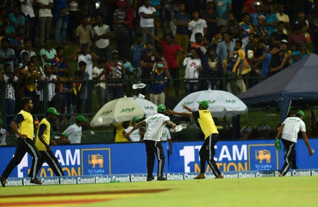 Groundsmen clear empty bottles as crowd interrupt game by throwing empty bottles on ground. (PTI) Groundsmen clear empty bottles as crowd interrupt game by throwing empty bottles on ground. (PTI)