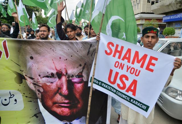 Supporters of Defence of Pakistan Council, a coalition of around 40 religious and political parties, carry banners during a protest against US President Donald Trump in Karachi on August 25, 2017. Angry and offended Pakistanis fired back against Donald Trump's accusations that their country harbours militants, highlighting the heavy toll they have paid fighting extremism and slamming his embrace of arch-rival India. (AFP)