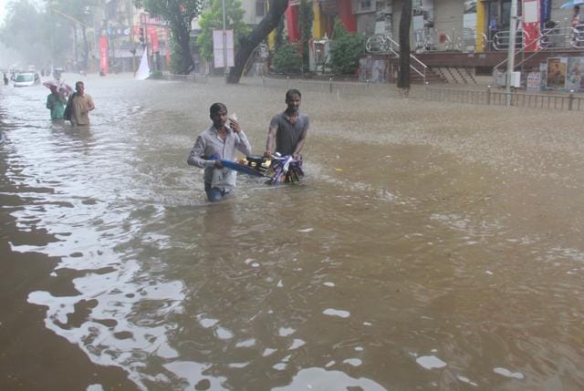 People walk through a flooded street at Hindamata in Mumbai on Tuesday. (Pratik Chorge/HT Photo) People walk through a flooded street at Hindamata in Mumbai on Tuesday. (Pratik Chorge/HT Photo)