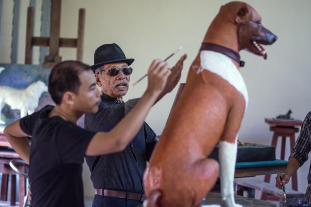 Thai sculptor Chin Prasong (C) gives indications to Pitchapong Parsing as Parsing gives the finishing touches of paint to a sculpture of one of the dogs owned by the late Thai King on August 31, 2017. (AFP Photo) Thai sculptor Chin Prasong (C) gives indications to Pitchapong Parsing as Parsing gives the finishing touches of paint to a sculpture of one of the dogs owned by the late Thai King on August 31, 2017. (AFP Photo)
