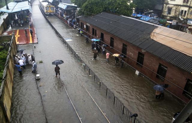 In this Tuesday, Aug. 29, 2017 file photo, people walk past a waterlogged railway station during heavy rainfall in Mumbai, India. For India's financial capital Mumbai and other South Asian cities and farmlands, floods are regular, cataclysmic occurrences made worse by breakneck urban development and population booms that will only become more challenging as climate change increases disaster risk. (AP) In this Tuesday, Aug. 29, 2017 file photo, people walk past a waterlogged railway station during heavy rainfall in Mumbai, India. For India's financial capital Mumbai and other South Asian cities and farmlands, floods are regular, cataclysmic occurrences made worse by breakneck urban development and population booms that will only become more challenging as climate change increases disaster risk. (AP)