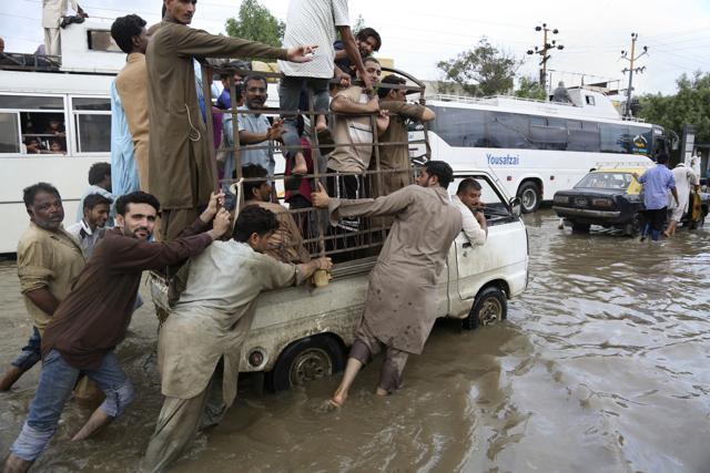 People push a vehicle after heavy rainfall in Karachi on August 31, 2017. (AP)