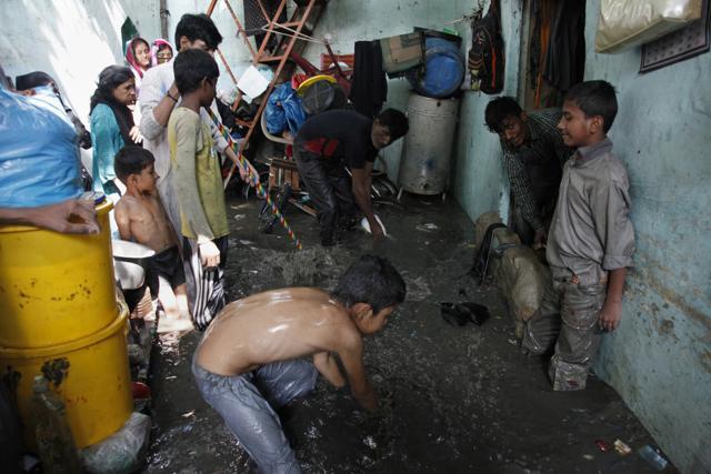 A Pakistani family tries to remove rainwater from its inundated home following heavy monsoon rains in Karachi on August 31, 2017. (AP)