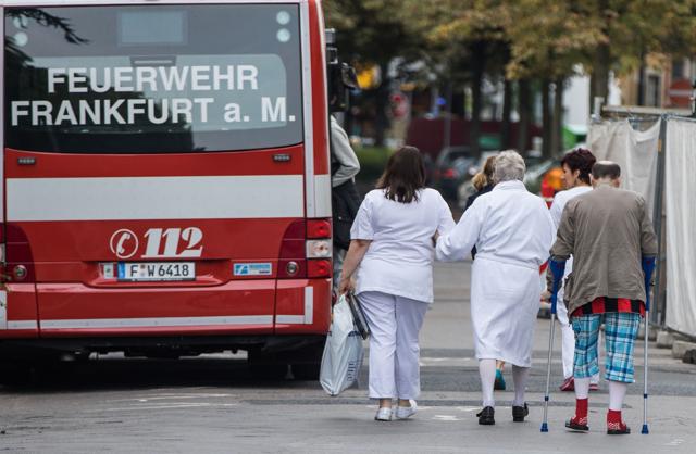 Patients of the Buergerhospital clinic are being accompanied to an amublance car in order to be moved to another hospital in Frankfurt am Main, western Germany, as evacuation measures are under way due to the found of a British WWII bomb. (AFP Photo) Patients of the Buergerhospital clinic are being accompanied to an amublance car in order to be moved to another hospital in Frankfurt am Main, western Germany, as evacuation measures are under way due to the found of a British WWII bomb. (AFP Photo)
