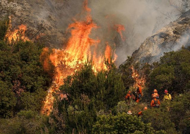 A crew with the California Department of Forestry and Fire Protection battles a brushfire on the hillside in Burbank. (AP) A crew with the California Department of Forestry and Fire Protection battles a brushfire on the hillside in Burbank. (AP)
