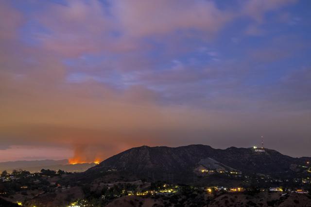Photo shows the La Tuna Fire burning (left), and the Hollywood sign seen at sunset from Los Angeles. (AP) Photo shows the La Tuna Fire burning (left), and the Hollywood sign seen at sunset from Los Angeles. (AP)
