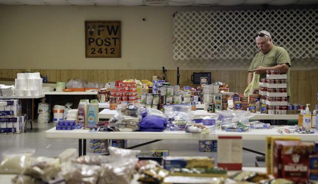 In this Sept. 1, 2017, photo, Freddie Driver gathers items from the VFW Post being used as a distribution center, in Sargent, Texas. (AP) In this Sept. 1, 2017, photo, Freddie Driver gathers items from the VFW Post being used as a distribution center, in Sargent, Texas. (AP)