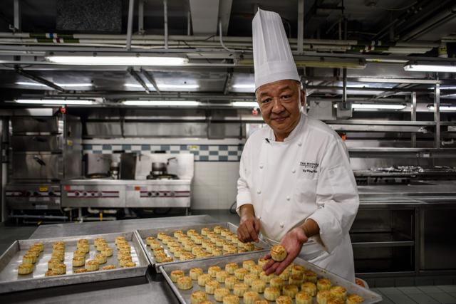 Chef Yip Wing-wah displays his freshly baked signature "spring moon mini egg custard mooncakes". (AFP) Chef Yip Wing-wah displays his freshly baked signature "spring moon mini egg custard mooncakes". (AFP)