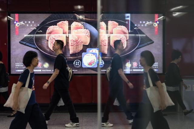 People walk past an advertisement for mooncakes in a train station in Hong Kong. (AFP) People walk past an advertisement for mooncakes in a train station in Hong Kong. (AFP)