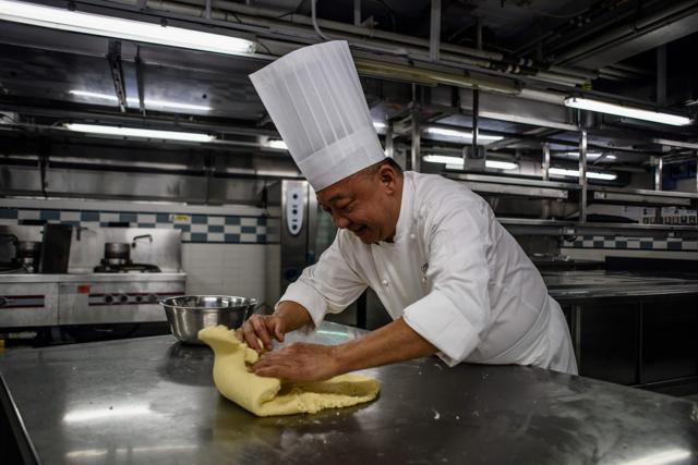 Chef Yip Wing-wah kneads dough as he makes his signature "spring moon mini egg custard mooncakes". (AFP) Chef Yip Wing-wah kneads dough as he makes his signature "spring moon mini egg custard mooncakes". (AFP)