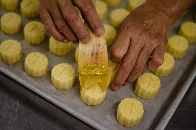 Chef Yip Wing-wah brushes fresh egg yolk on his pre-baked signature "spring moon mini egg custard mooncakes". (AFP) Chef Yip Wing-wah brushes fresh egg yolk on his pre-baked signature "spring moon mini egg custard mooncakes". (AFP)