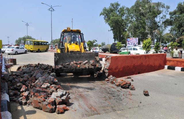 A JCB machine demolishing a wall to make way for the CM’s convoy at Jagraon Bridge in Ludhiana on Tuesday. (Gurminder Singh/HT) A JCB machine demolishing a wall to make way for the CM’s convoy at Jagraon Bridge in Ludhiana on Tuesday. (Gurminder Singh/HT)
