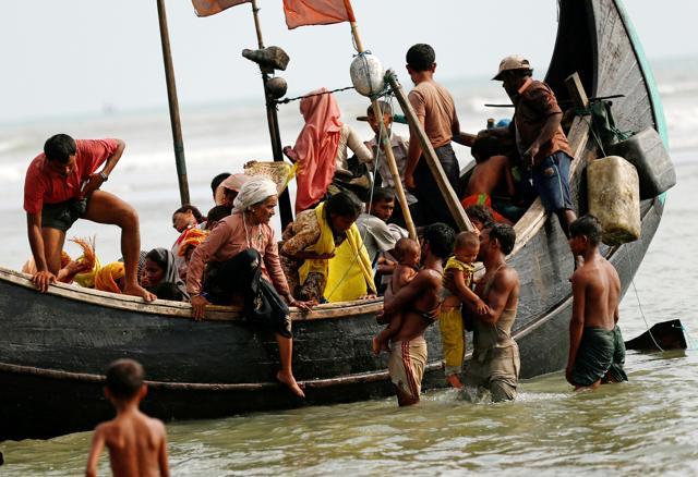 Rohingya refugees get off to the boat as they arrive in Bangladesh by boat through the Bay of Bengal in Teknaf, Bangladesh, on September 5. (REUTERS)