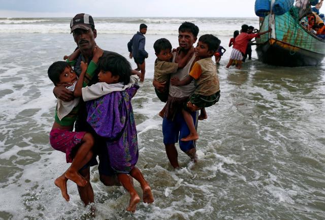 Rohingya refugee children are carried to the shore after crossing the Bangladesh-Myanmar border by boat through the Bay of Bengal in Teknaf, Bangladesh, on September 7, 2017. (Reuters)