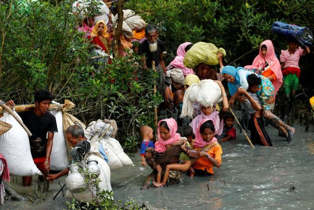 Rohingya refugees walk through water after crossing border by boat through the Naf River in Teknaf, Bangladesh on September 7. (REUTERS)
