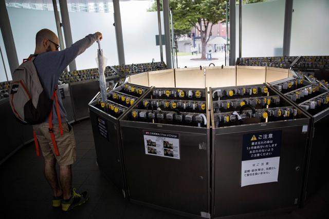 A foreign tourist puts his umbrella in an umbrella lock-up in Tokyo's National Art Centre. (AFP/Behrouz Mehri )