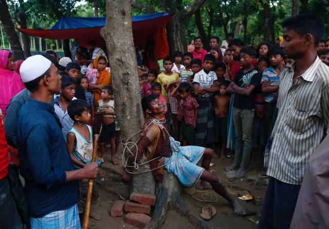 A man accused of stealing money from Rohingya refugees is tied to a tree at a makeshift refugee camp near Balukhali in Cox's Bazar, Bangladesh. (Reuters Photo) A man accused of stealing money from Rohingya refugees is tied to a tree at a makeshift refugee camp near Balukhali in Cox's Bazar, Bangladesh. (Reuters Photo)