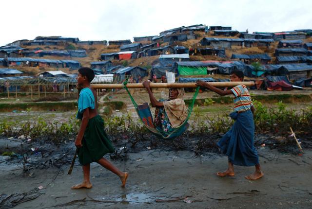 Rohingya refugee children carry an old woman in a sling near Balukhali makeshift refugee camp in Cox's Bazar, Bangladesh. (Reuters Photo) Rohingya refugee children carry an old woman in a sling near Balukhali makeshift refugee camp in Cox's Bazar, Bangladesh. (Reuters Photo)