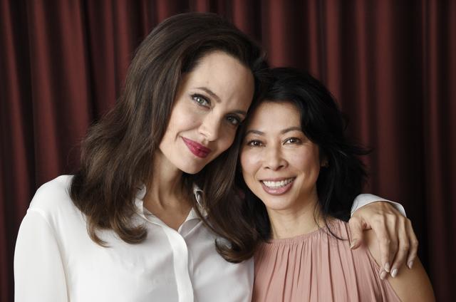 Angelina Jolie, left, director/co-writer of the film First They Killed My Father: A Daughter of Cambodia Remembers, and co-writer/human rights activist Loung Ung pose for a portrait during the Toronto International Film Festival. (Chris Pizzello/Invision/AP)