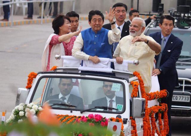 Prime Minister Narendra Modi, Japanese Prime Minister Shinzo Abe and his wife Akie Abe wave from an open vehicle during their roadshow in Ahmedabad on Wednesday. (PTI)