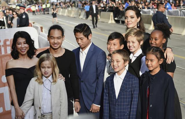 Vivienne Jolie-Pitt, front row from left, Knox Jolie-Pitt, Sareum Srey Moch, middle row from left, Loung Ung, Maddox Jolie-Pitt, Pax Jolie-Pitt, Kimhak Mun, Shiloh Jolie-Pitt, Zahara Jolie-Pitt and Angelina Jolie attend a premiere for First They Killed My Father. (Evan Agotini/Invision/AP)