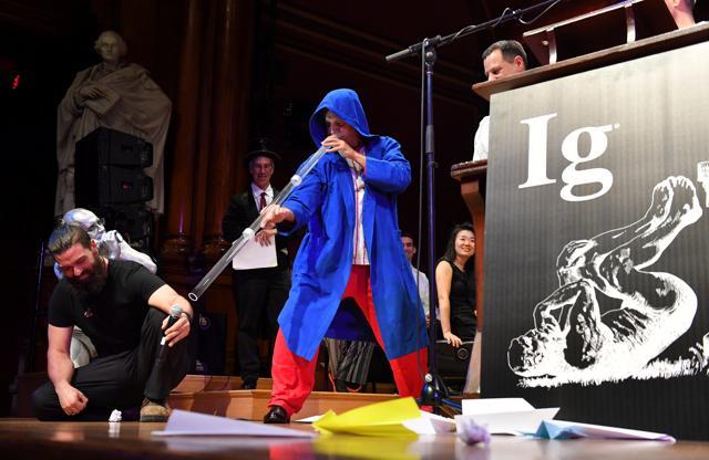 Didgeridoo instructor Alex Suarez, center, demonstrates the Ig Nobel Peace prize-winning study, "Didgeridoo Playing as Alternative Treatment for Obstructive Sleep Apnoea Syndrome," during the 27th First Annual Ig Nobel Prize Ceremony at Harvard University. (REUTERS)