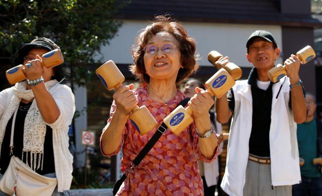 Elderly and middle-aged people exercise with vigour. (Toru Hanai/Reuters)