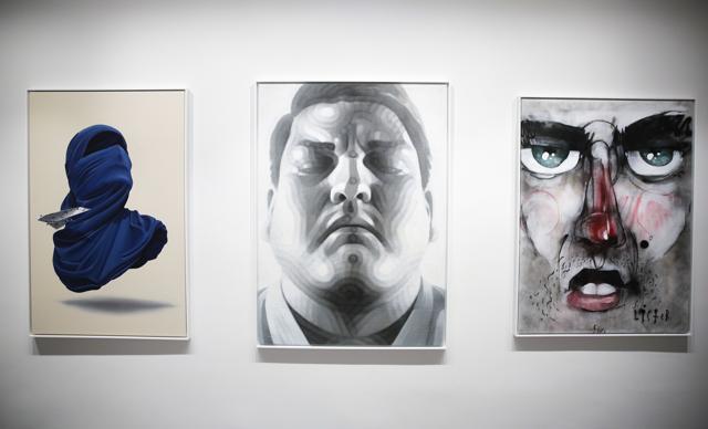 The paintings (from left), Shirt Mask x Paper Plane by Numo Viegas, The Fighter by El Mac and Street Face by Lister displayed at the exhibition. (AP)