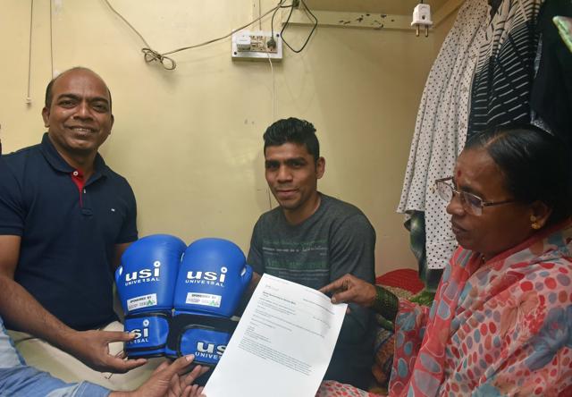Akshay Mare (centre) with his mother and Santosh Jagdhane, head of CSR of Dorf Ketal, at Mare's house in Pune, showing the boxing gloves and sponsorship certificate. (Pratham Gokhale/HT PHOTO) Akshay Mare (centre) with his mother and Santosh Jagdhane, head of CSR of Dorf Ketal, at Mare's house in Pune, showing the boxing gloves and sponsorship certificate. (Pratham Gokhale/HT PHOTO)