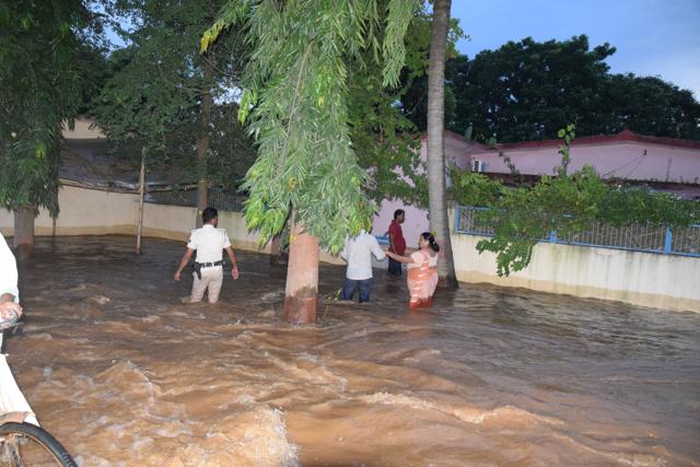 Local residents in Bihar’s Kahalgaon struggle through water gushing from a breached canal. (HT Photo)