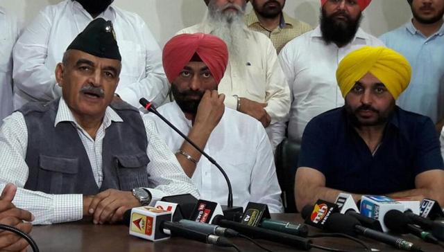 From right: AAP candidate for Gurdaspur Lok Sabha bypoll Maj Gen Suresh Khajuria (Retd), leader of Opposition Sukhpal Singh Khaira, and Sangrur MP Bhagwant Mann addressing a press conference in Jalandhar on Sunday. (HT File )