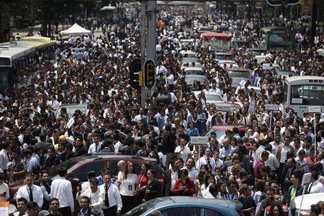 People evacuated from office buildings gather in Reforma Avenue after an earthquake in Mexico City. (AP Photo)