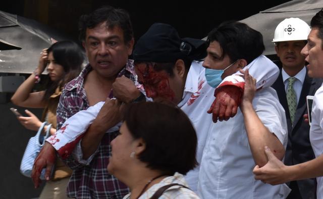 People help a wounded man after an earthquake in Mexico City. (AFP) People help a wounded man after an earthquake in Mexico City. (AFP)